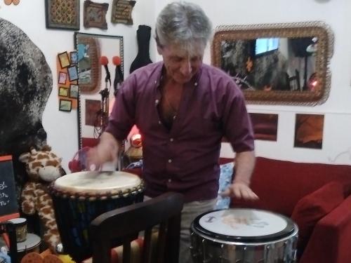 an older woman playing drums in a room at G H Hostal VIP in Buenos Aires