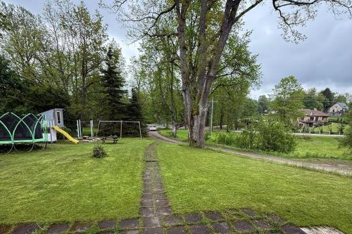 an empty park with a playground and a tree at Stylish Cesis Apartment - Perfect Base for Exploring Medieval Town and Gauja Nature Trails in Cēsis