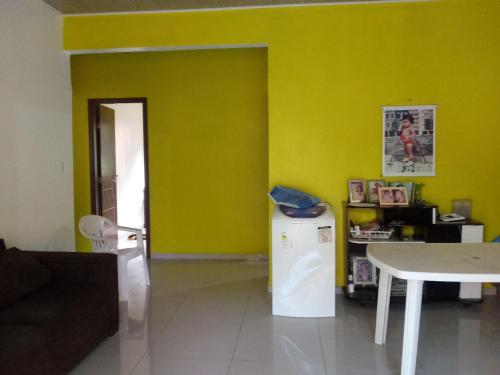 a living room with a yellow wall and a table at Casa São Francisco in Belém
