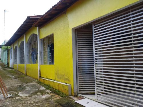 a yellow building with a garage door on the side of it at Casa São Francisco in Belém