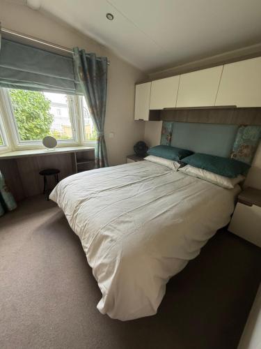 New HunstantonにあるModern 6 birth caravan Hunstanton Norfolkの大きな白いベッドと窓のある寝室