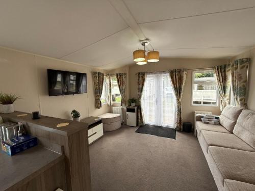 a living room with a couch and a table at Modern 6 birth caravan Hunstanton Norfolk in New Hunstanton