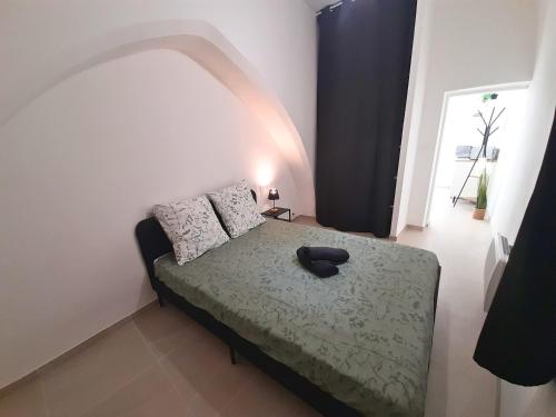 une chambre avec un lit avec un chapeau dessus dans l'établissement Le Refuge de l'Écusson - T2 centre-ville, WIFI, à Montpellier