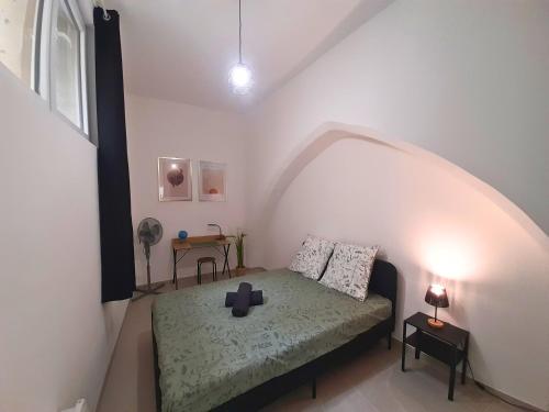 Cette chambre comprend un lit avec une croix. dans l'établissement Le Refuge de l'Écusson - T2 centre-ville, WIFI, à Montpellier