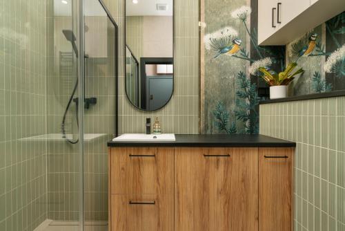 un baño con lavabo y ducha en Hugo4You Apartments, en Wroclaw