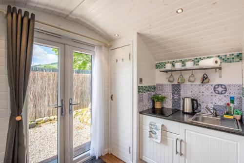 a kitchen with a sink and a window at Loch Ness Hideaway Pod in Lewiston
