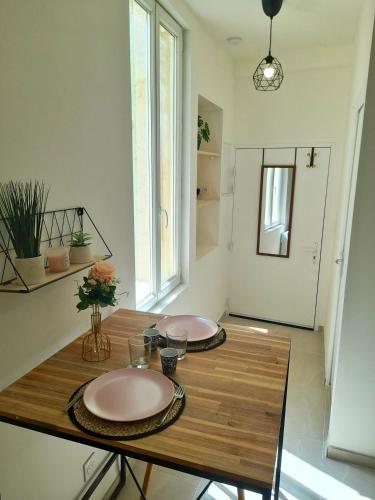 2 assiettes sur une table en bois dans une pièce dans l'établissement Le Refuge de l'Écusson - T2 centre-ville, WIFI, à Montpellier