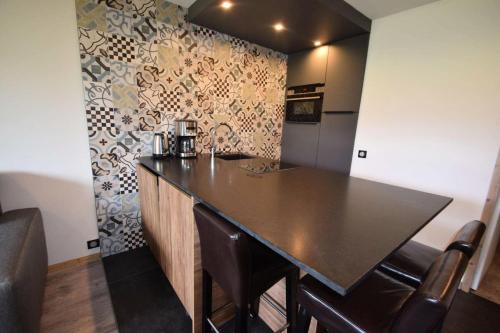 - une cuisine avec un bar et un comptoir dans l'établissement Résidence Les Gentianes - 2 Pièces 4 pers -LES GENTIANES - PLAGNE VILLAGES -Classé 3- WIFI MAE-1944, à Aime La Plagne