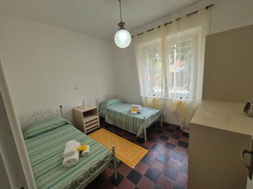 カルボーニアにあるCasa Vacanze Fiori di Linaのベッドが2つと窓がある小さな部屋