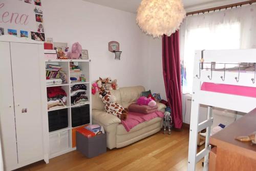 ein Schlafzimmer mit einem Sofa und einem Etagenbett in der Unterkunft Maison Familiale au coeur d'aulnay sud, proche gare, aéroport CDG, Parc des expositions in Aulnay-sous-Bois