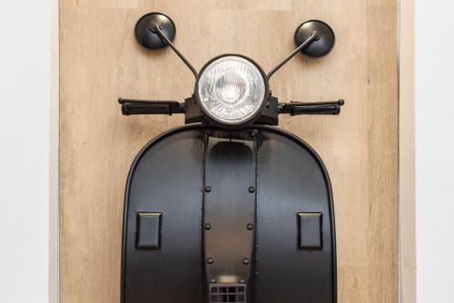 a black scooter parked next to a wooden wall at NG Guest House l'Acquedotto in Olbia