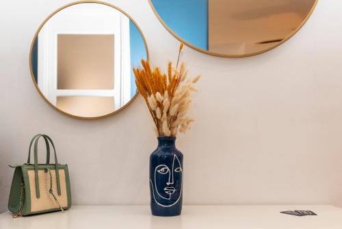 a blue vase sitting on a counter with a mirror at NG Guest House l'Acquedotto in Olbia