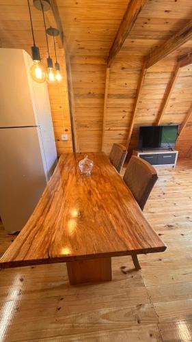 a wooden table in a room with a kitchen at Chalé do Lago in Toledo