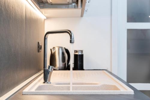 a kitchen sink with a faucet in a kitchen at NG Guest House l'Acquedotto in Olbia