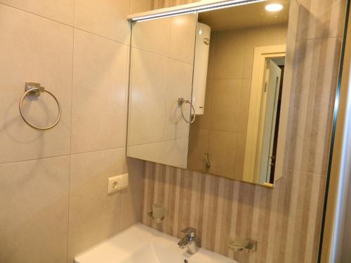 a bathroom with a sink and a mirror at orbi beach tower in Itʼkhvisi