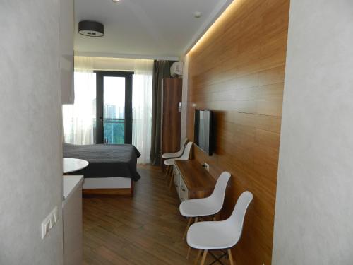 a small room with a bed and a desk and chairs at orbi beach tower in Itʼkhvisi