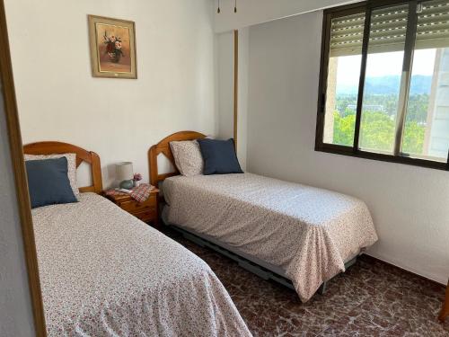 ein Schlafzimmer mit zwei Betten und einem Fenster in der Unterkunft Apartamento Acogedor con Piscina, Cerca de la Playa in Playa de Gandia