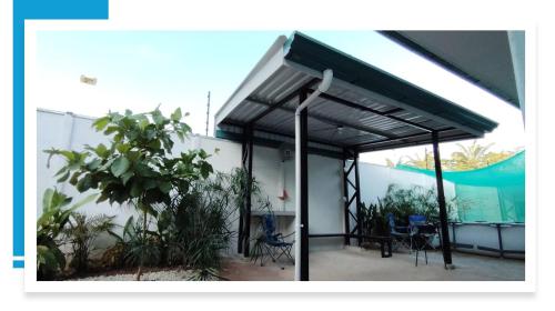 a building with a roof with chairs and a plant at Villa Blue Vacations in Parrita