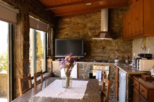 a kitchen with a table with a vase of flowers on it at Casa do Passadiço in Espiunca