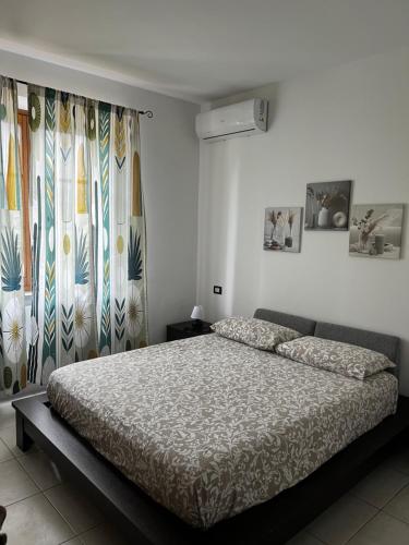 a bedroom with a bed and two windows with curtains at Podere Venanzio in Lido di Camaiore