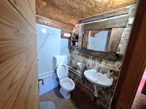 a small bathroom with a toilet and a sink at The LODGE in Risan