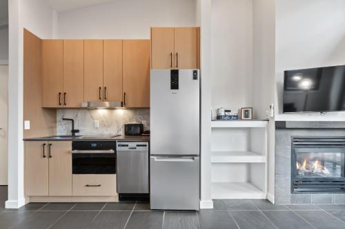 a kitchen with a white refrigerator and a fireplace at Black Rock Oceanfront Resort in Ucluelet