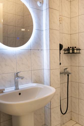 a bathroom with a sink and a shower at Ellinas Hotel in Chrysi Ammoudia