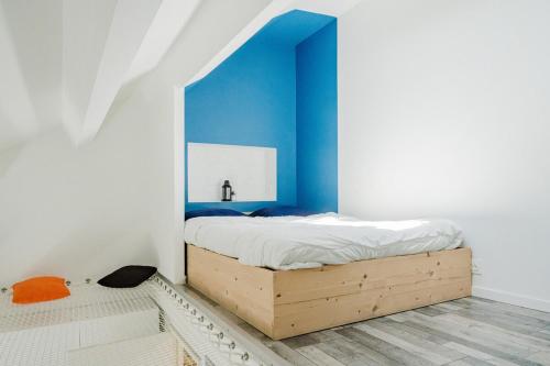 a bedroom with a bed with a blue wall at Studio 5, à 5min de la gare avec WIFI in Lens