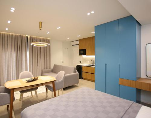 a room with a bed and a table and a kitchen at Gledors Luxury Apartments in Vlorë