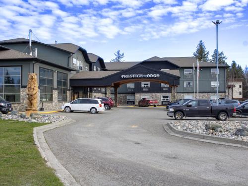 a large building with cars parked in a parking lot at Prestige Prince George Lodge in Prince George