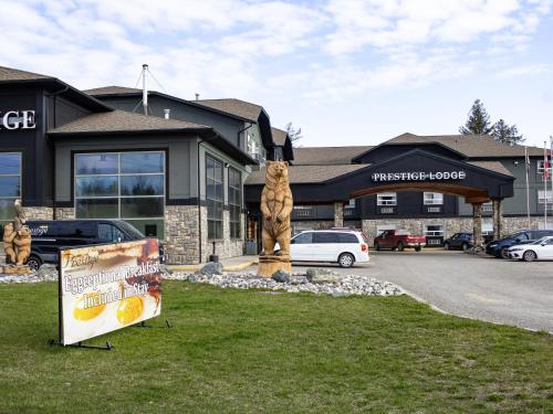 a sign in the grass in front of a building at Prestige Prince George Lodge in Prince George