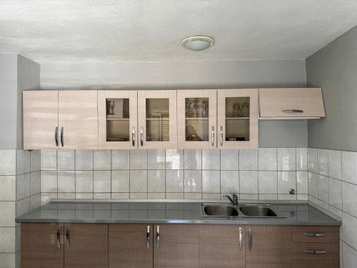 a kitchen with wooden cabinets and a sink at Lantana ex Villa Americana in Karlobag