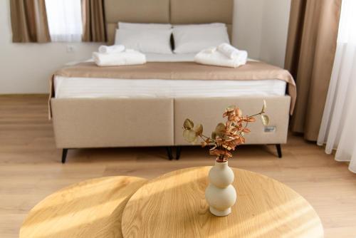 a vase on a table in a room with a bed at Carmen Old Town Apartments in Sarajevo