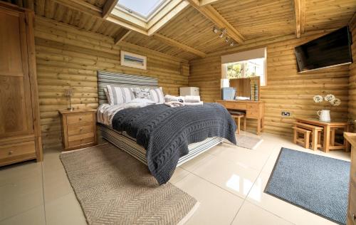een slaapkamer met een bed in een houten hut bij Downsfield Bed and Breakfast in St Ives