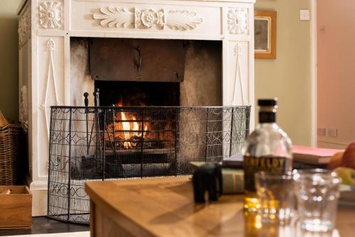 a fireplace in a living room with a fire place at The West Wing, Capheaton 