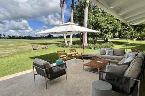 un patio con sofá y sombrilla en Golf Villa V, en La Romana