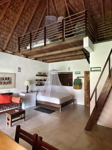 a bedroom with a large bed and a loft at Cabañas Uma 2 in San Agustinillo