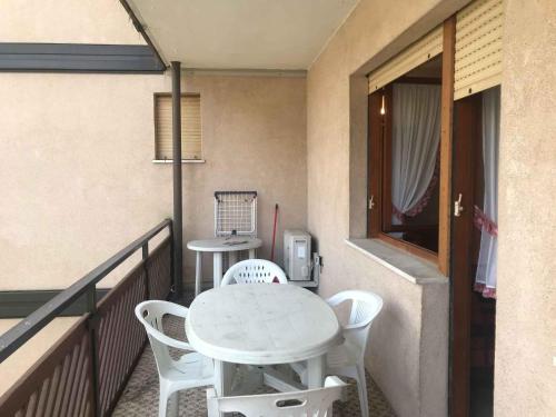 a white table and chairs on a balcony at Apartments in Lido di Jesolo 54509 in Lido di Jesolo
