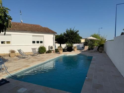 a swimming pool in front of a house at Villa avec piscine in Le Crès