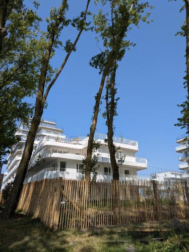 a white building with trees in front of it at Ti Malo - studio proche plage Dunkerque in Dunkerque
