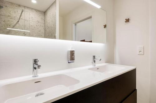a bathroom with two sinks and a mirror at The Ghentian Suites by Domani Hotels in Ghent