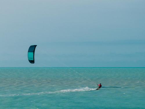 a man is kite surfing in the ocean at Casa Las Tortugas Petit Beach Hotel & Spa in Holbox Island