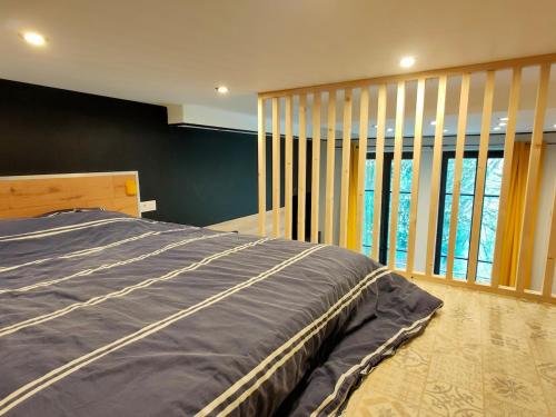 a bedroom with a bed and a large window at Loft moderne dans un palace bourgeois in Aix-les-Bains