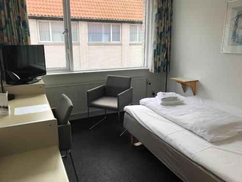 a room with a bed and a desk and a chair at Hotel Norden in Haderslev