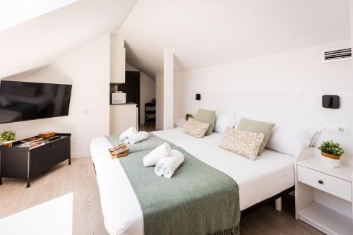 a bedroom with two beds and a flat screen tv at Hostel Charino in Pontevedra