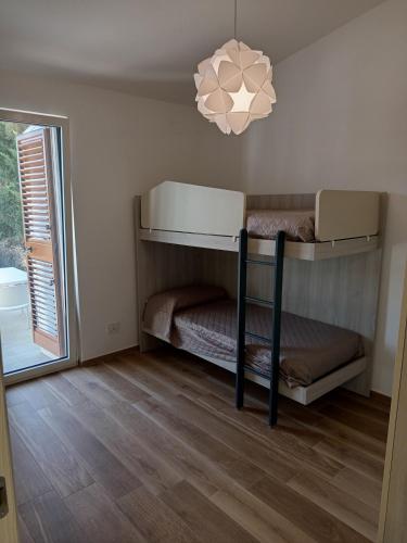 a room with two bunk beds and a chandelier at Murgia pool retreat in Cassano delle Murge