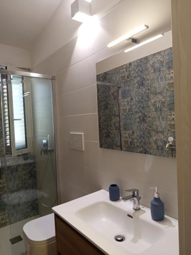 a bathroom with a sink and a toilet and a shower at Murgia pool retreat in Cassano delle Murge