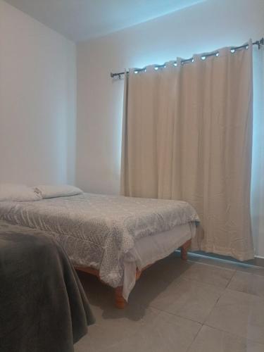 a bedroom with a bed and a curtain at Casa San Rafael Moderna y Elegante in Saltillo