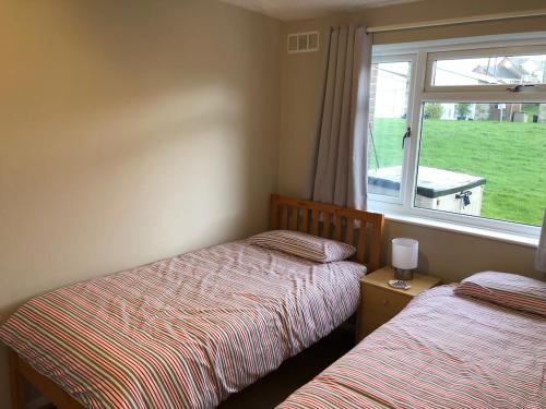 Dos camas en una habitación con ventana. en Fort Albert, en Freshwater