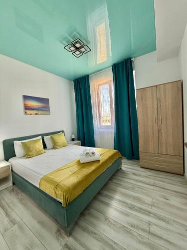a bedroom with a large bed with blue walls and curtains at Happy Apartments Mamaia Nord 2 Camere in Mamaia Sat/Năvodari